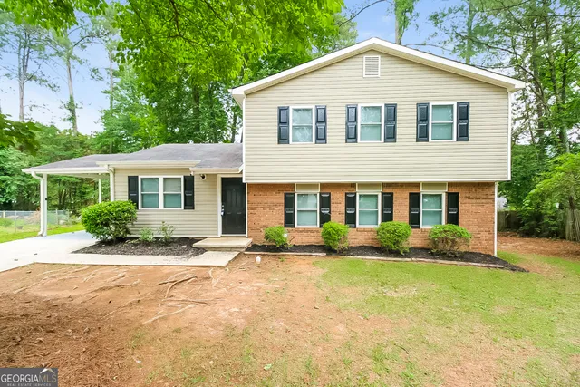 a front view of a house with a yard and potted plants