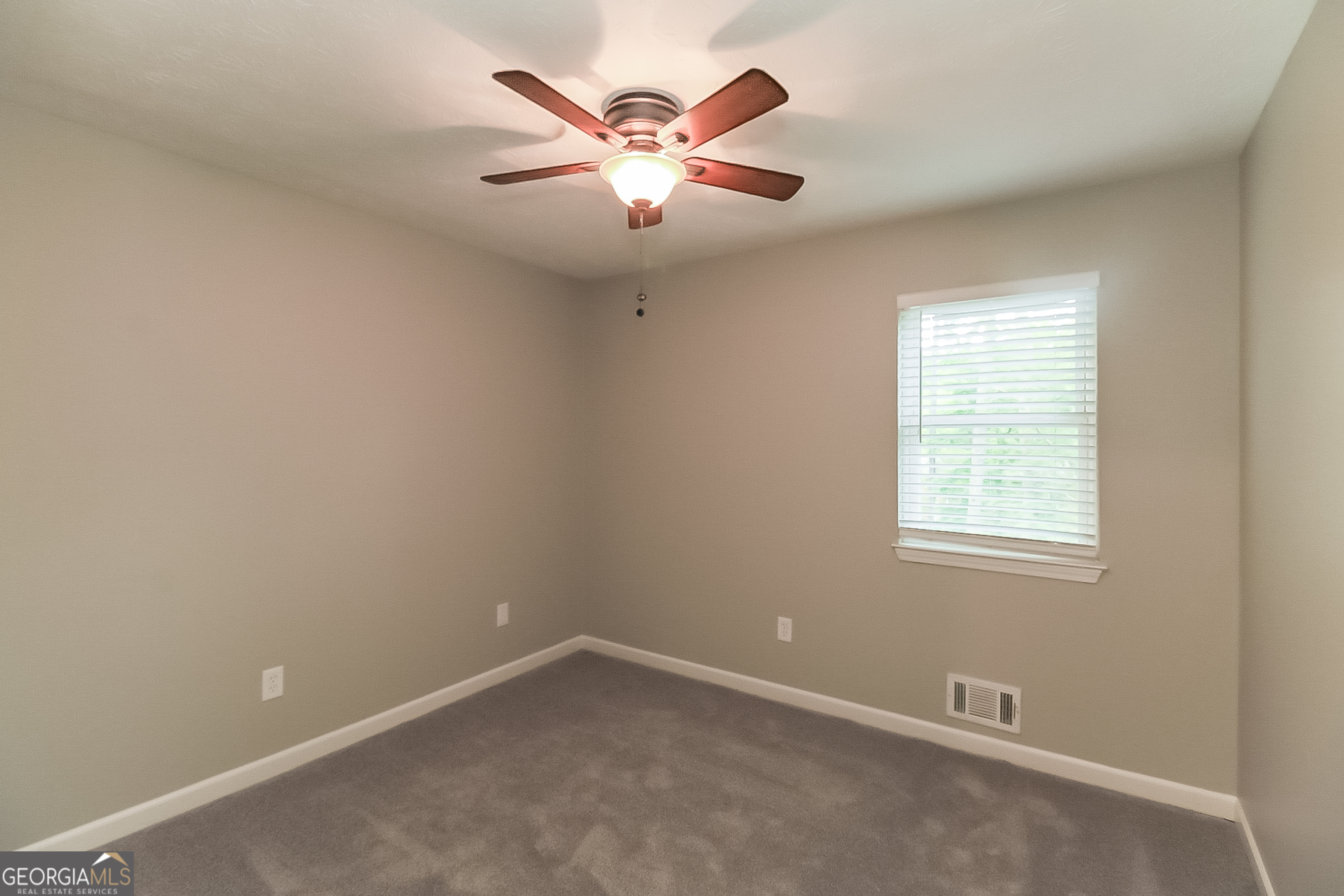 7548 Colonial Court Jonesboro, GA 30236 - Photo 12 of 17 an empty room with window and ceiling fan