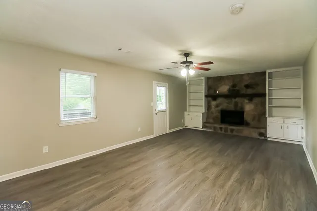 an empty room with a fireplace and window
