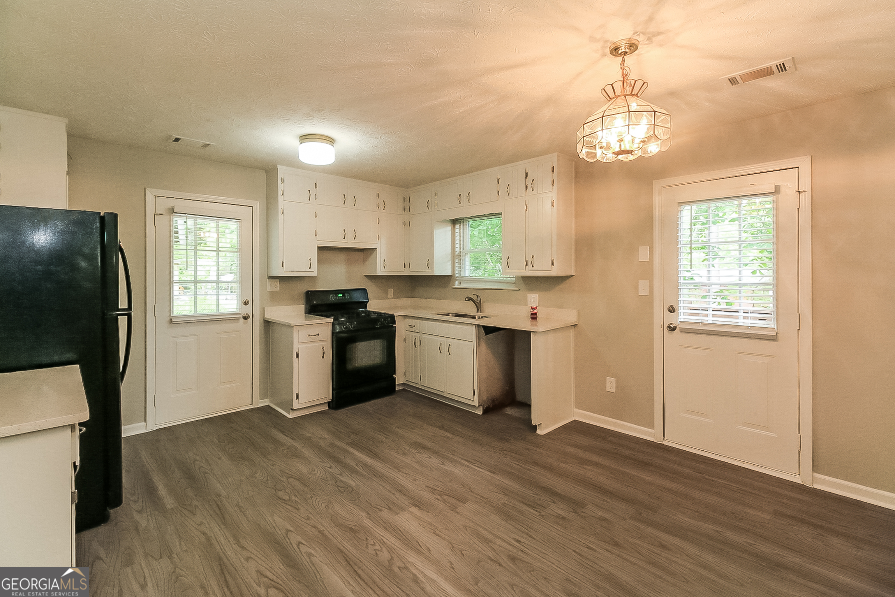7548 Colonial Court Jonesboro, GA 30236 - Photo 4 of 17 a kitchen with granite countertop wooden floors stainless steel appliances and window