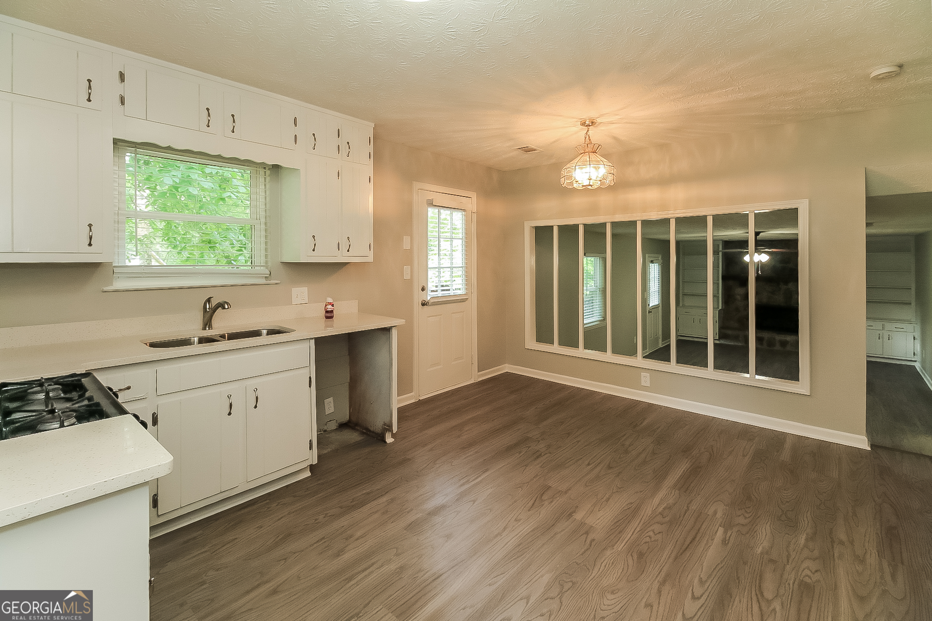 7548 Colonial Court Jonesboro, GA 30236 - Photo 5 of 17 a kitchen with wooden floors and white cabinets