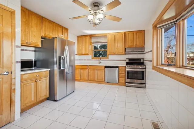 a kitchen with stainless steel appliances granite countertop a stove top oven a refrigerator a sink and dishwasher