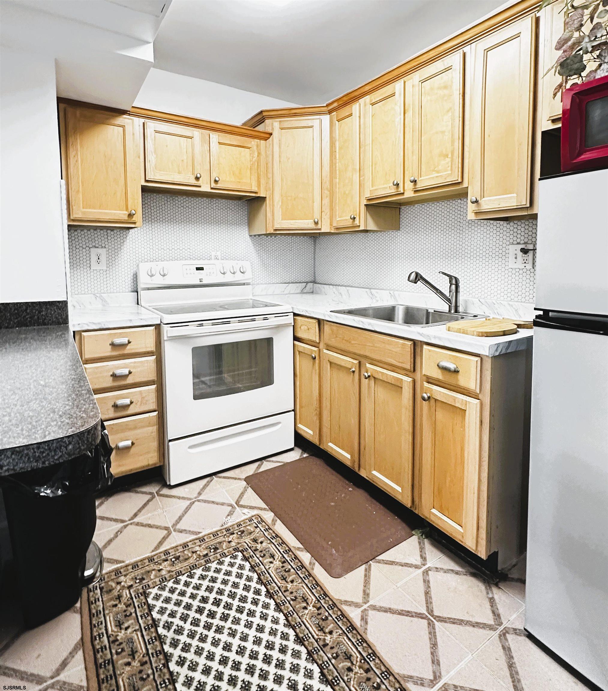101 South Raleigh Avenue, Unit 232 Atlantic City, NJ 08401 - Photo 3 of 18 a kitchen with a stove a sink and a microwave