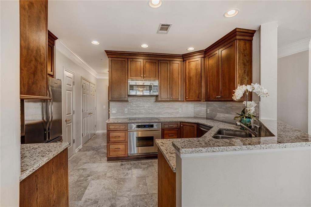 3334 Peachtree Road Northeast, Unit 1208 Atlanta, GA 30326 - Photo 7 of 23 a kitchen that has a sink and a stove in it