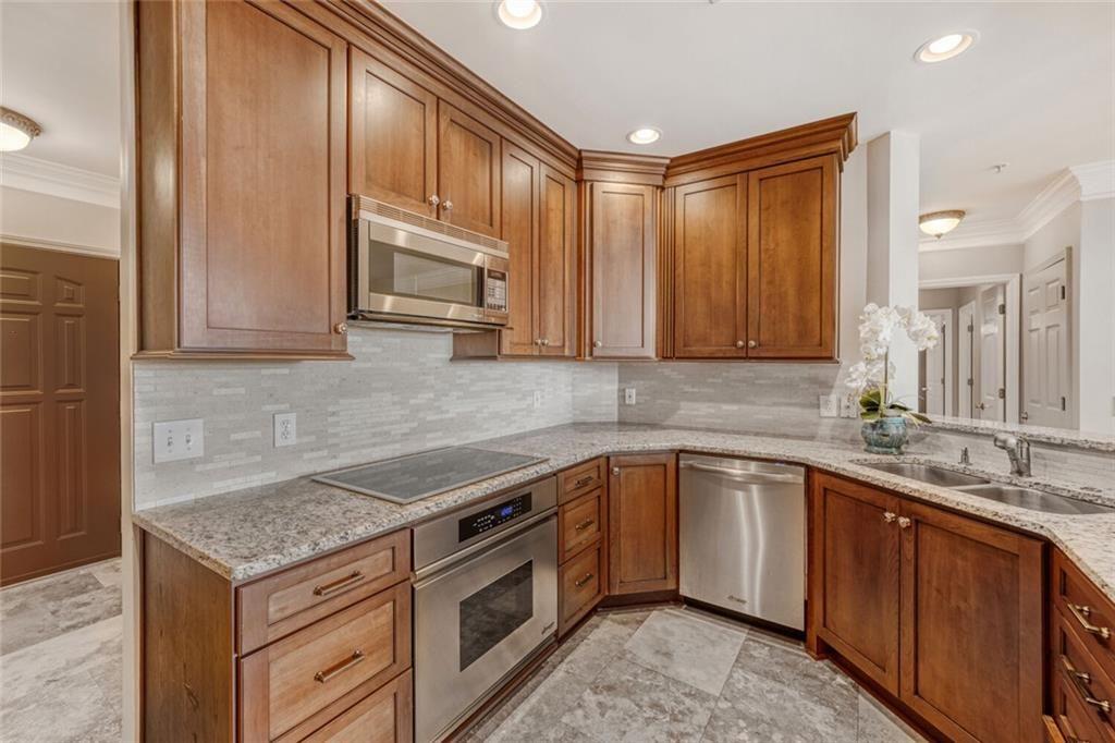 3334 Peachtree Road Northeast, Unit 1208 Atlanta, GA 30326 - Photo 9 of 23 a kitchen with stainless steel appliances granite countertop a sink stove and microwave