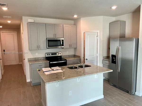 a kitchen with kitchen island a sink stainless steel appliances and refrigerator