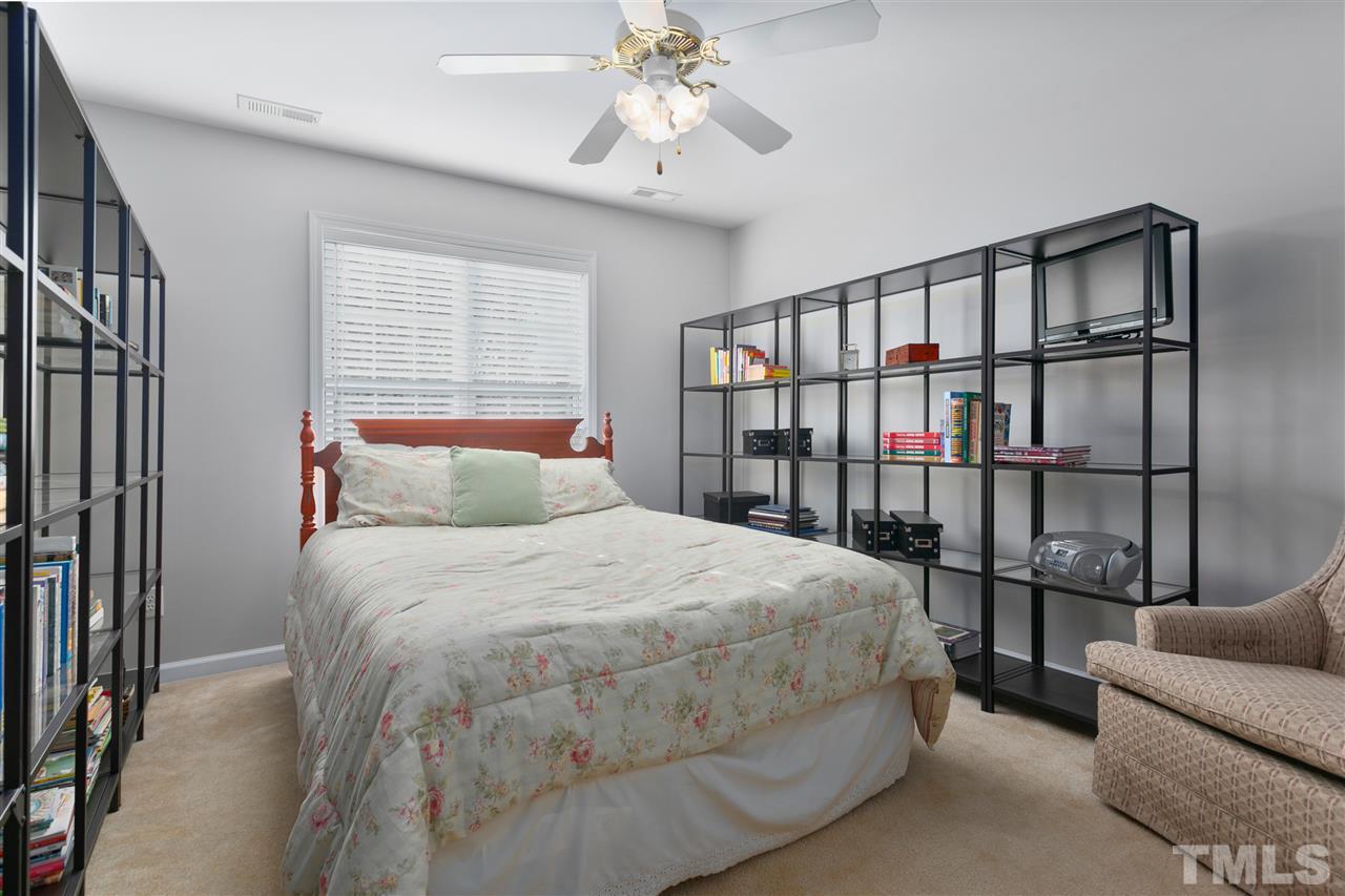 2744 Andover Glen Road Raleigh, NC 27604 - Photo 19 of 29 a bedroom with a large bed and a chandelier