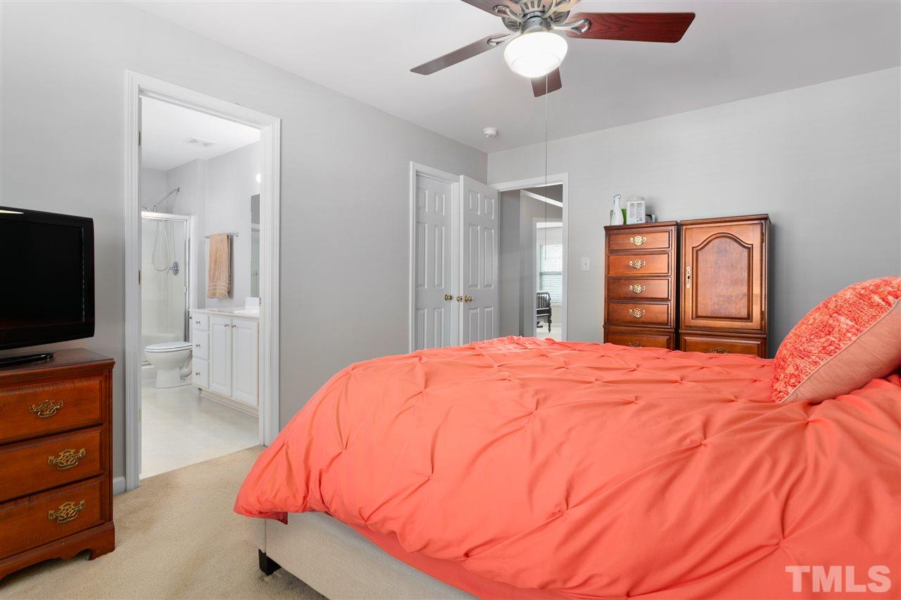 2744 Andover Glen Road Raleigh, NC 27604 - Photo 22 of 29 a bedroom with a bed and a flat tv screen on dresser