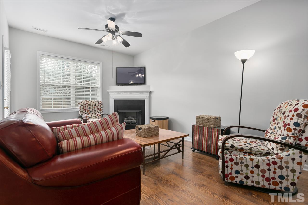 2744 Andover Glen Road Raleigh, NC 27604 - Photo 7 of 29 a living room with furniture a fireplace and a flat screen tv