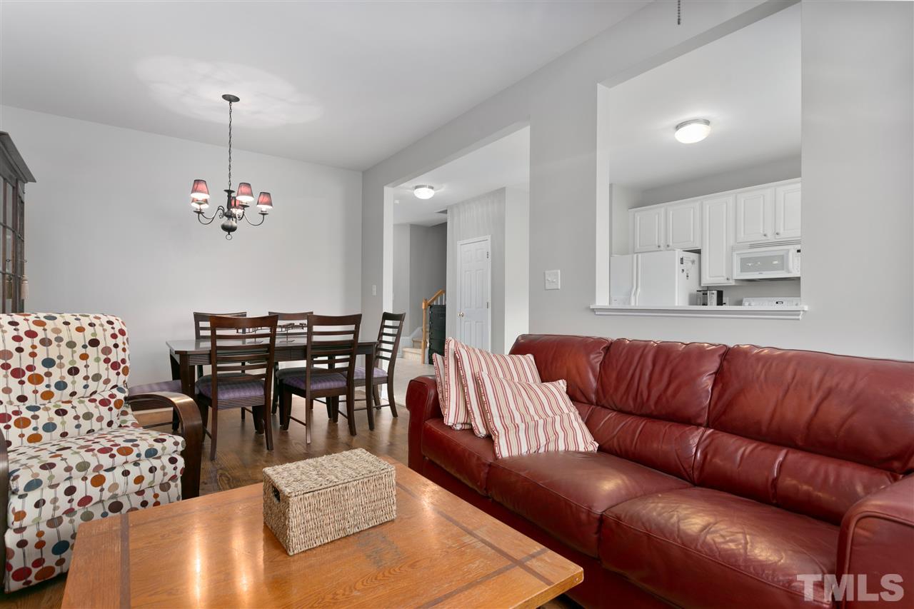 2744 Andover Glen Road Raleigh, NC 27604 - Photo 9 of 29 a living room with furniture a dining table and a chandelier