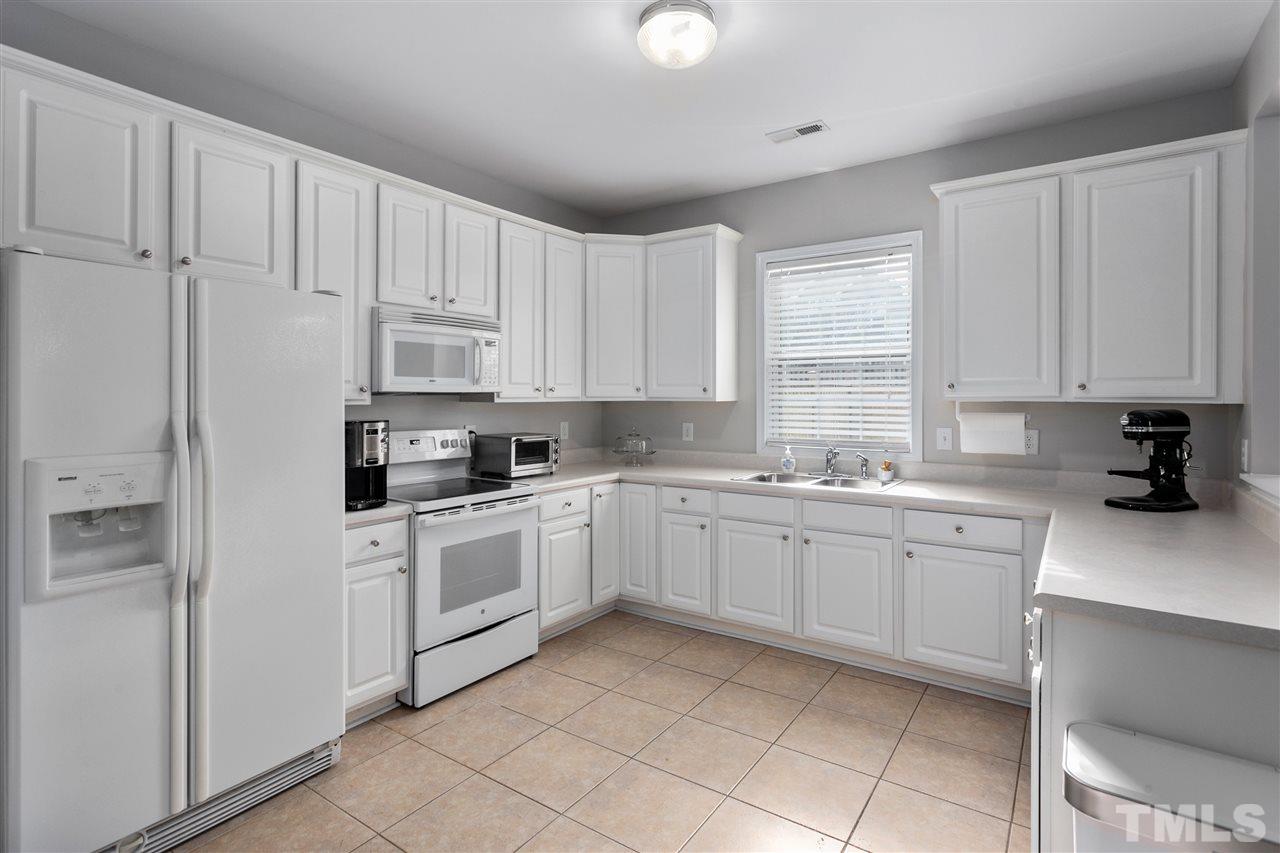2744 Andover Glen Road Raleigh, NC 27604 - Photo 10 of 29 a kitchen with cabinets appliances a sink and a window