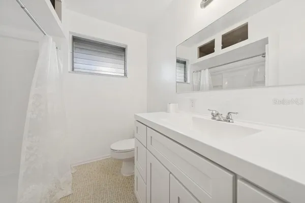 a bathroom with a sink a toilet and a mirror