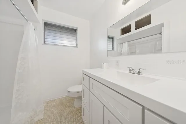 a bathroom with a sink a toilet and a mirror