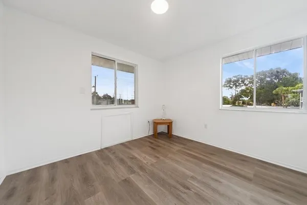 a view of empty room with wooden floor