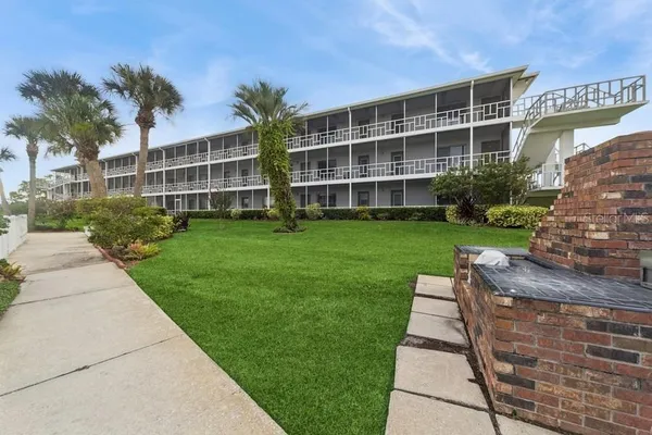 a front view of a building with a garden