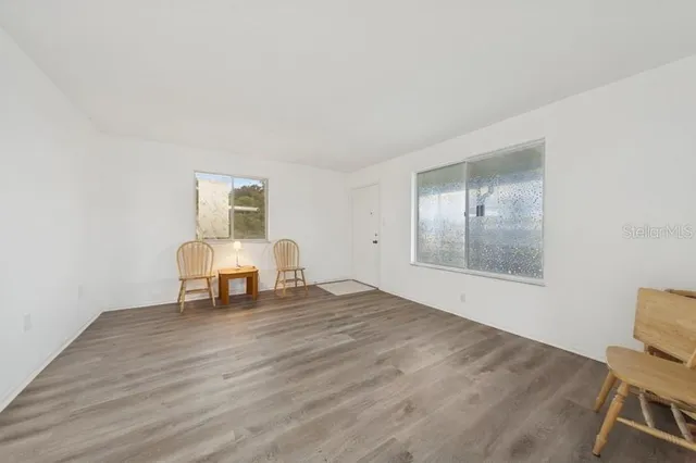 a view of work space with wooden floor and white walls