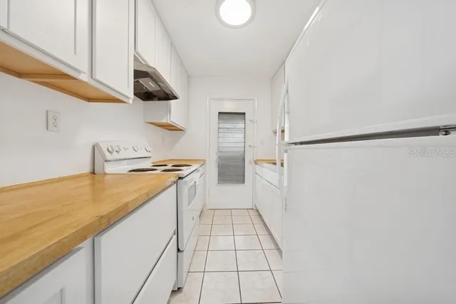 a kitchen with a sink a refrigerator and a stove