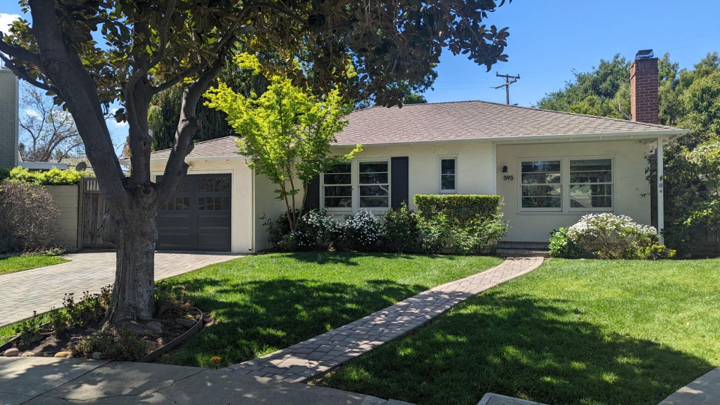 a front view of a house with yard and green space