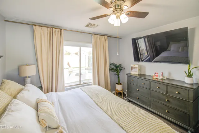 a bedroom with a large bed and a chandelier