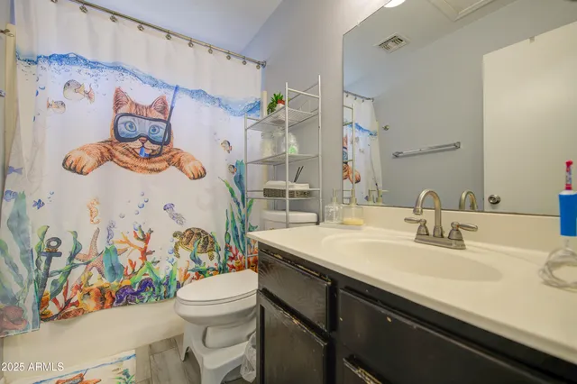 a bathroom with a sink a toilet and a shower curtain
