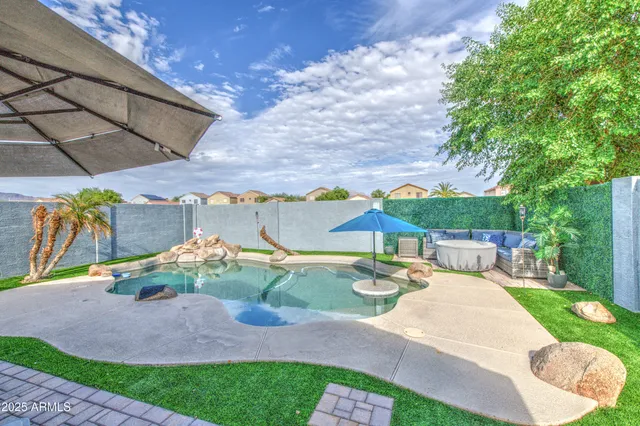 a view of a yard with table and chairs under an umbrella