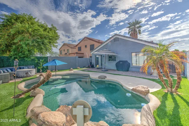 a view of a house with swimming pool and sitting area