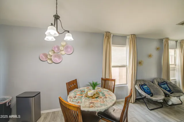 a view of a dining room with furniture a chandelier and wooden floor