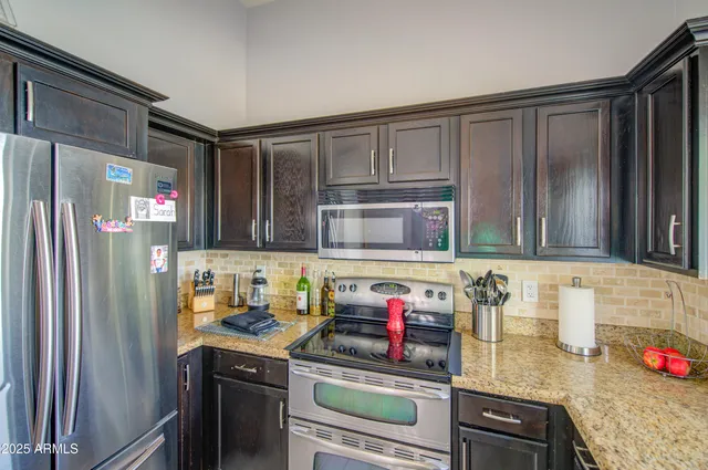 a kitchen with stainless steel appliances granite countertop a refrigerator and a stove