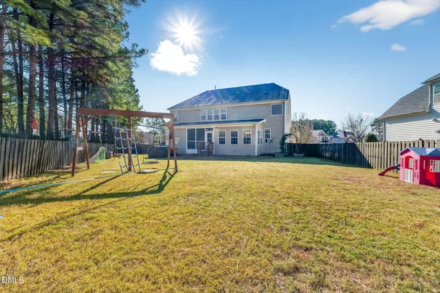 an aerial view of a house with a yard and wooden fence