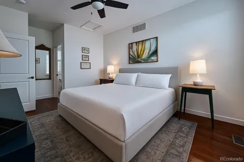 a spacious bedroom with a bed and a lamp