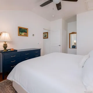 a bedroom with a bed and a lamp on dresser