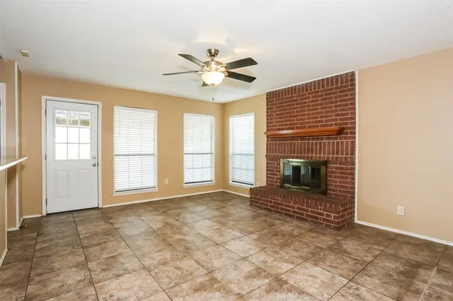 a view of an empty room with a fireplace and a window