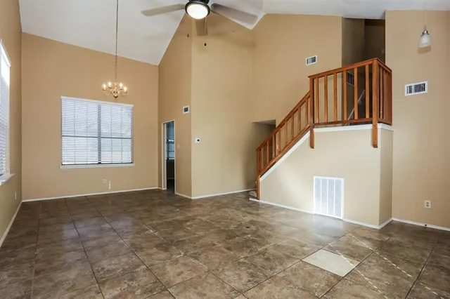 a view of an empty room with stairs and a window