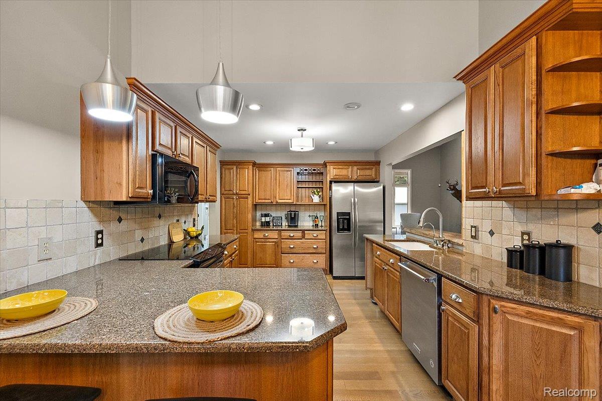 707 West Sutton Road Metamora, MI 48455 - Photo 33 of 84 Kitchen featuring wood cabinetry, stainless steel appliances, recessed lighting, and a tiled backsplash