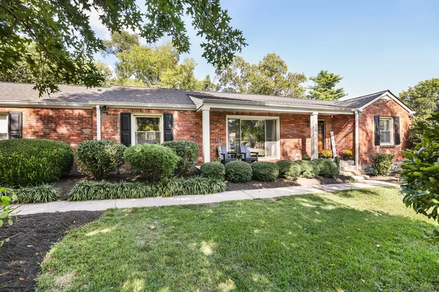 a front view of a house with a yard and potted plants