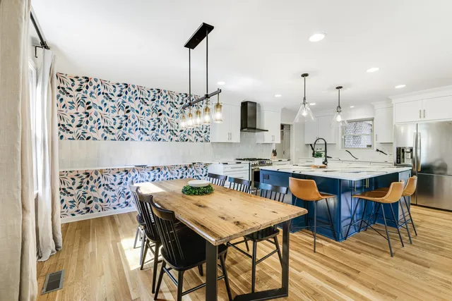 a kitchen with stainless steel appliances granite countertop a sink a stove and a wooden cabinets