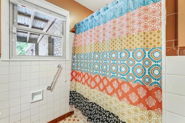 a bed sitting in a spacious bedroom next to a window