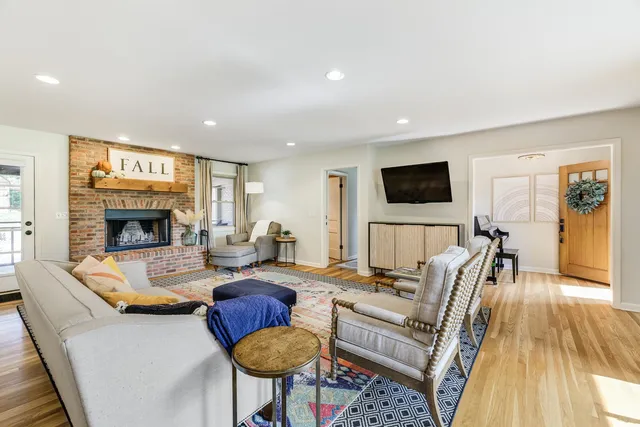 a living room with furniture a fireplace and a flat screen tv