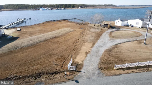 a living room with furniture kitchen view wooden floor and a large window