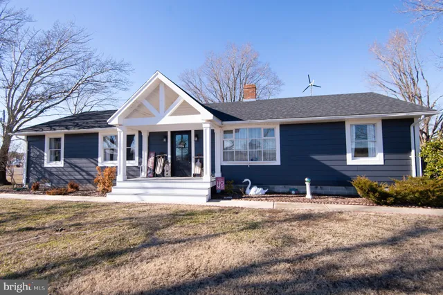 a front view of a house with a yard outdoor seating and garage
