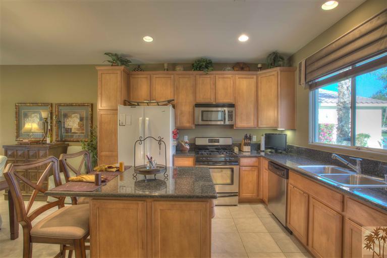 49121 Biery Street Indio, CA 92201 - Photo 7 of 25 a kitchen with kitchen island granite countertop a stove sink and cabinets