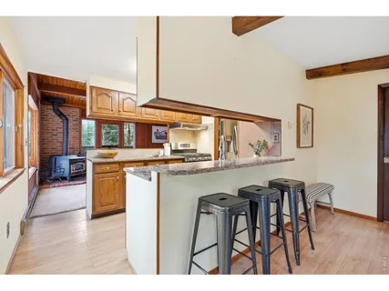 a kitchen with stainless steel appliances granite countertop a table and chairs