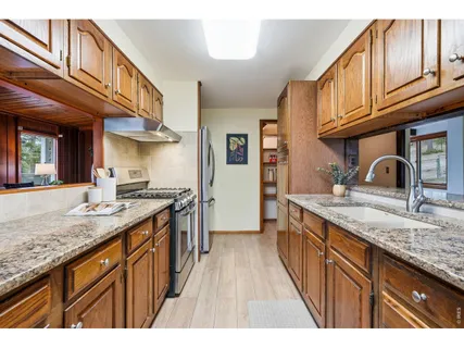 a kitchen with stainless steel appliances granite countertop a sink stove and cabinets