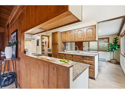 a dining hall with stainless steel appliances granite countertop a stove a sink and a wooden floors
