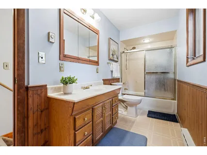 a bathroom with a sink a toilet a mirror and shower