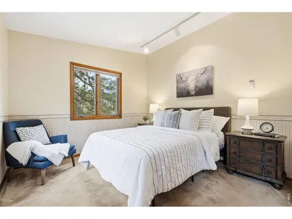 a bedroom with a bed a couch and painting on the wall