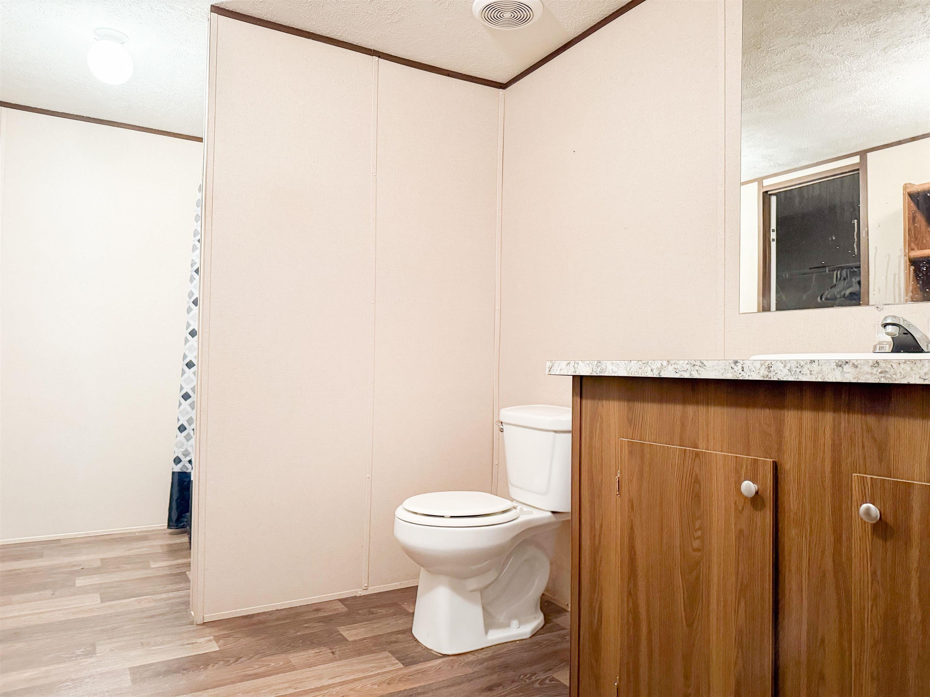 279 Travis Road Brewton, AL 36426 - Photo 9 of 17 Bathroom with a textured ceiling, vanity, light wood finished floors, and ornamental molding