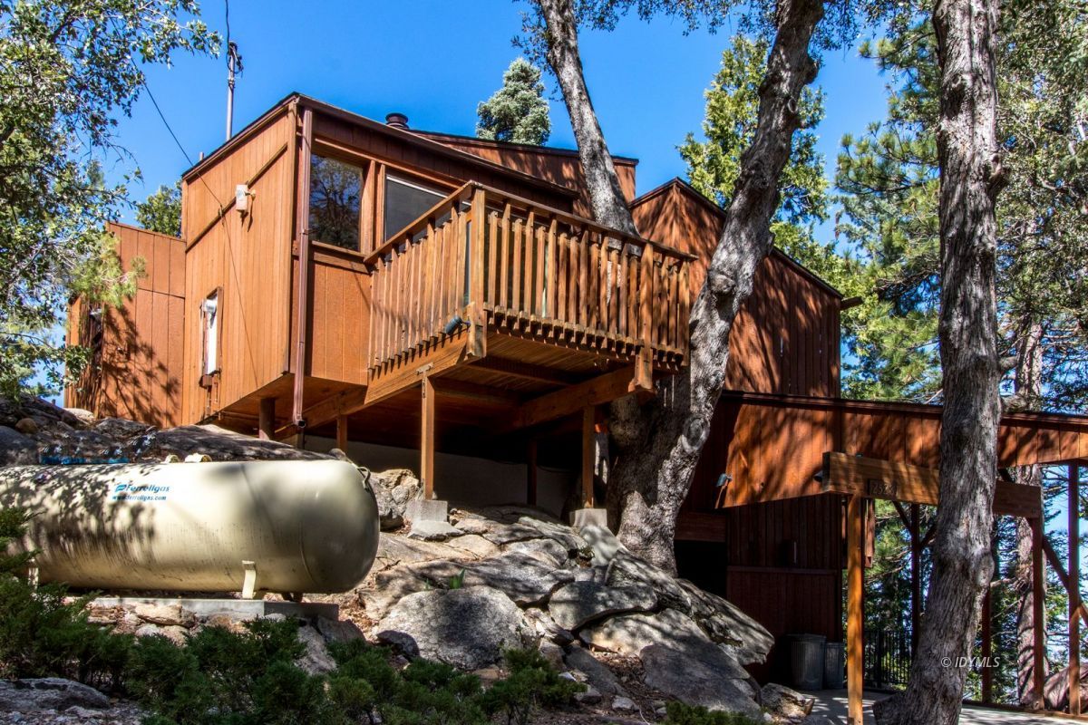 25281 Deer Path Road Pine Cove, CA 92549 - Photo 27 of 42 a backyard of a house with table and chairs under an umbrella