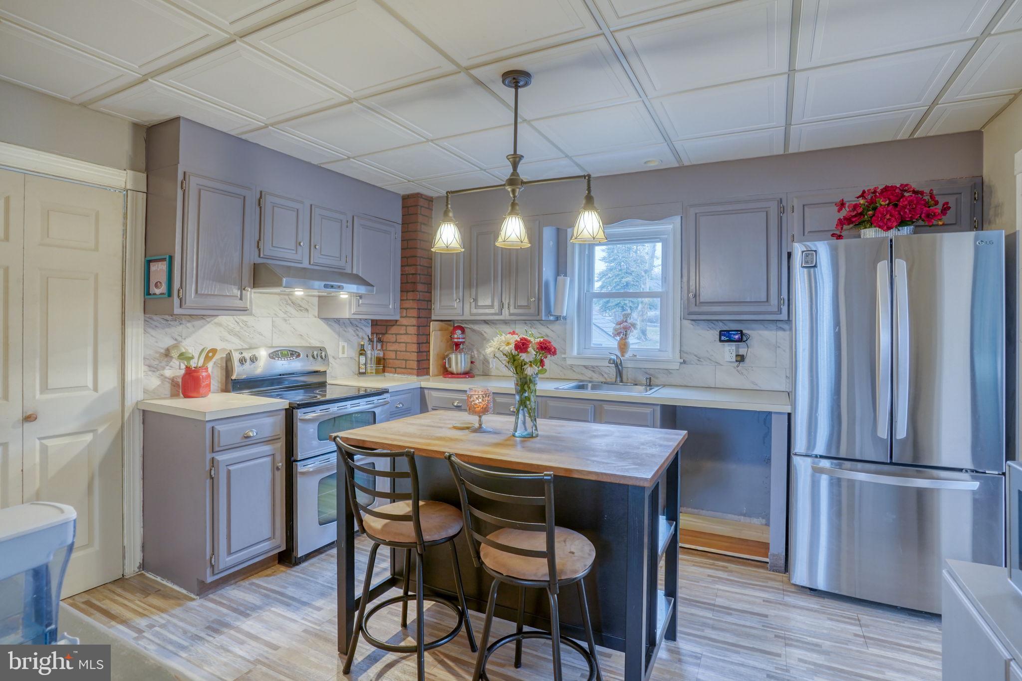 7 Patterson Avenue Perryville, MD 21903 - Photo 12 of 44 a kitchen with granite countertop a table chairs stove and refrigerator
