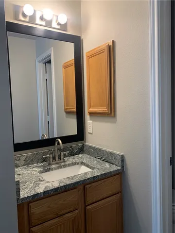 a bathroom with a granite countertop sink and a mirror
